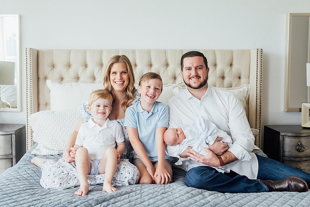 Family with three boys on bed for newborn session