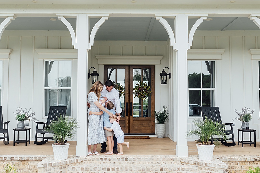 Family hugs on porch at newborn session