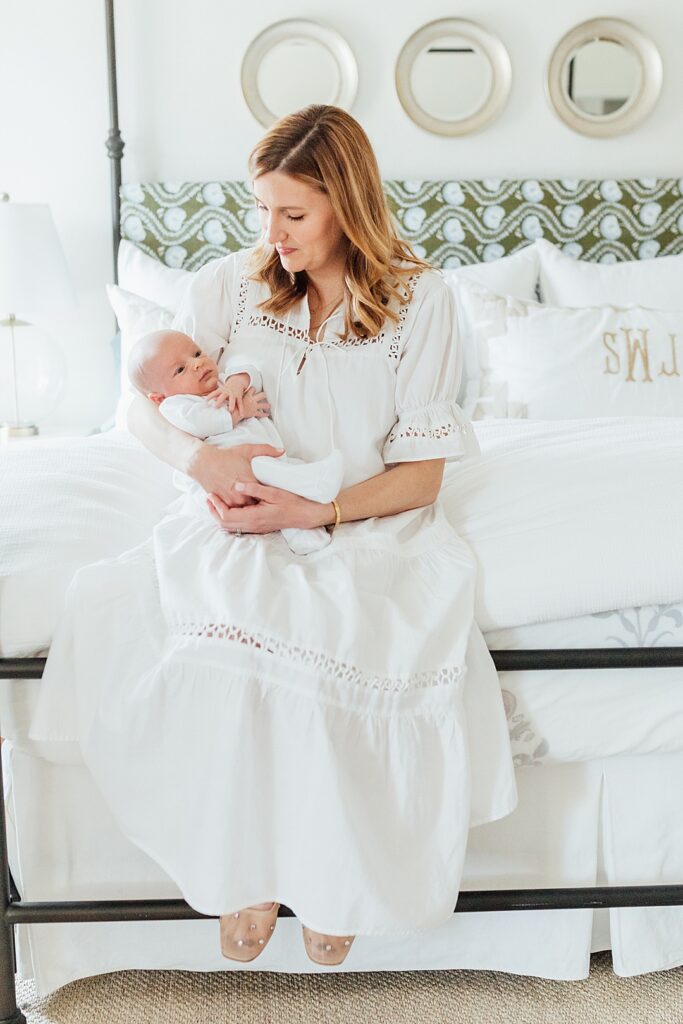 Mama and baby boy sitting on bed.