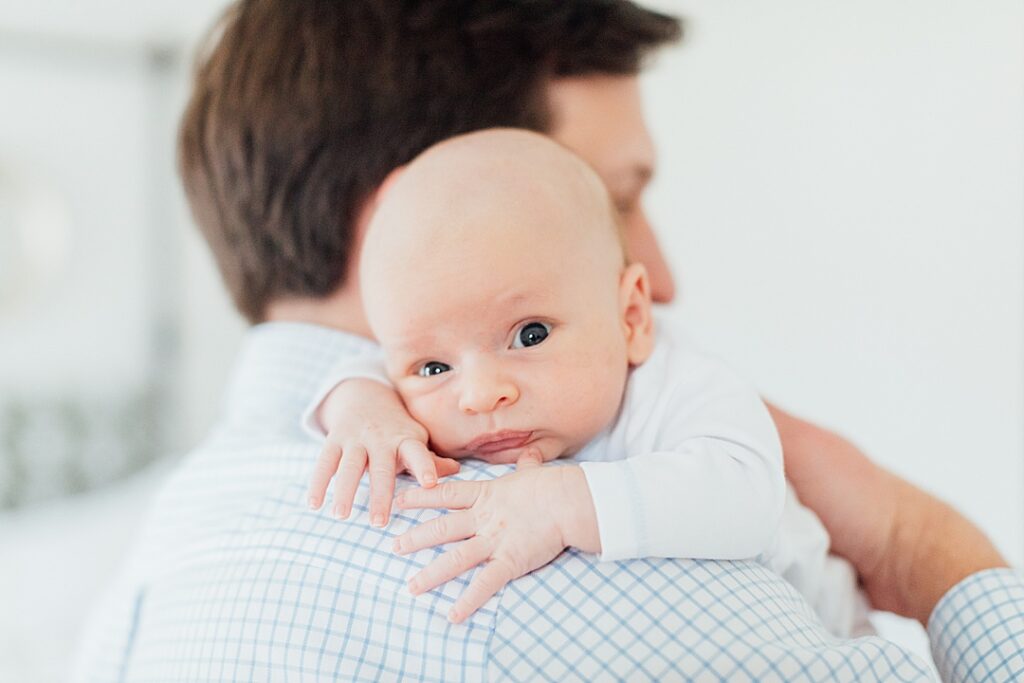 Baby boy on dad's shoulder.